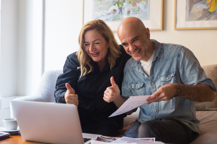 pais fazendo sinal de positivo em frente ao notebook