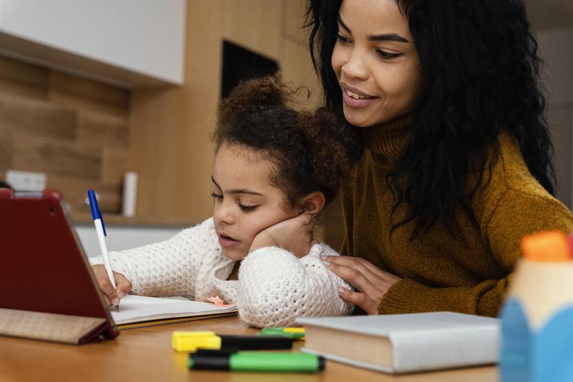 mãe ajudando filha na tarefa da escola