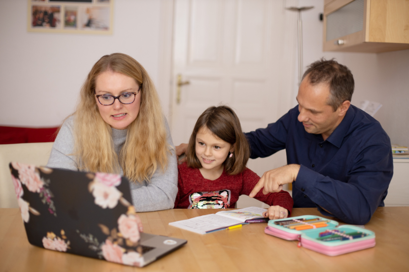 pais e filha procurando por escolas no computador