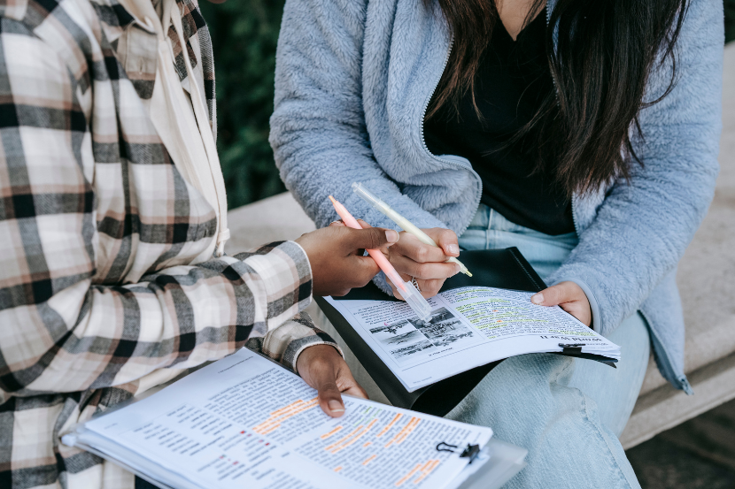 alunos estudando juntos com caderno de prova