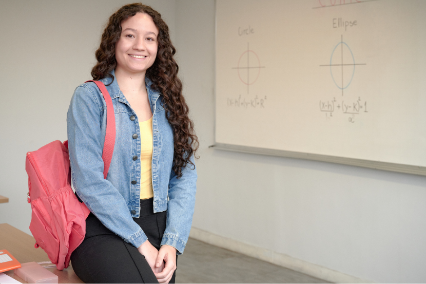 estudante adolescente com quadro de matemática ao fundo