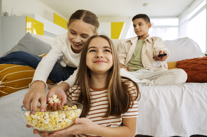 crianças assistindo filmes juntas no sofé