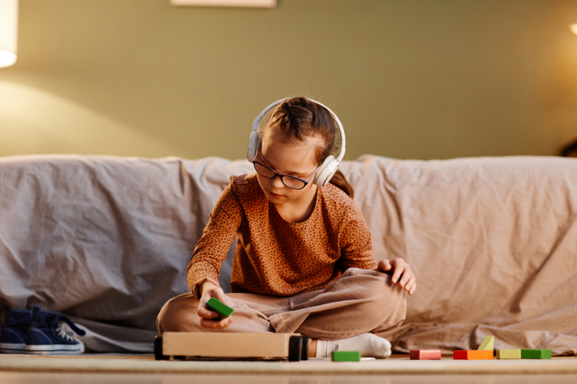 criança com neurodivergencia escutando música e brincando com blocos