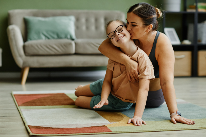 mãe abraçando e beijando a filha neurodivergente