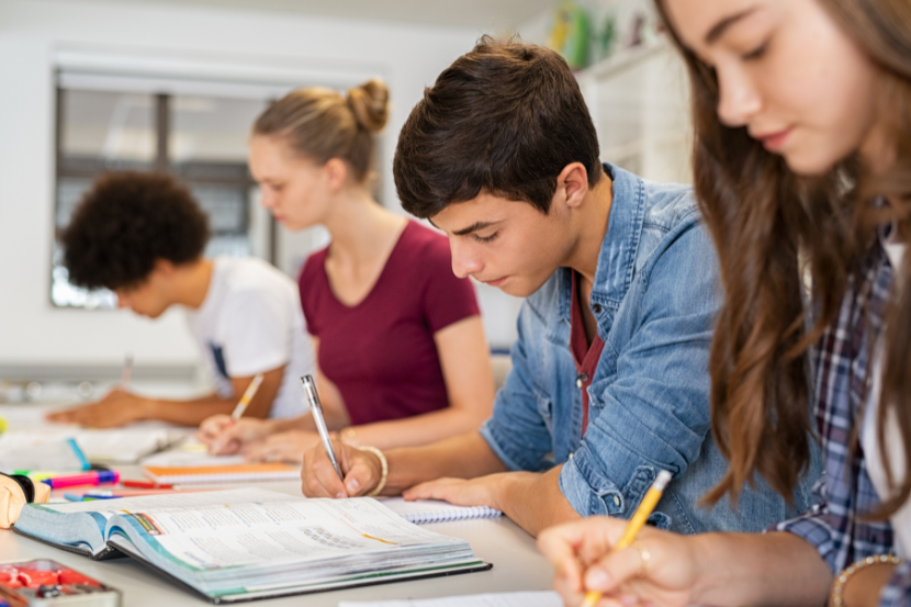 o que é ensino médio integral alunos do ensino médio integral concentrados estudando em sala de aula