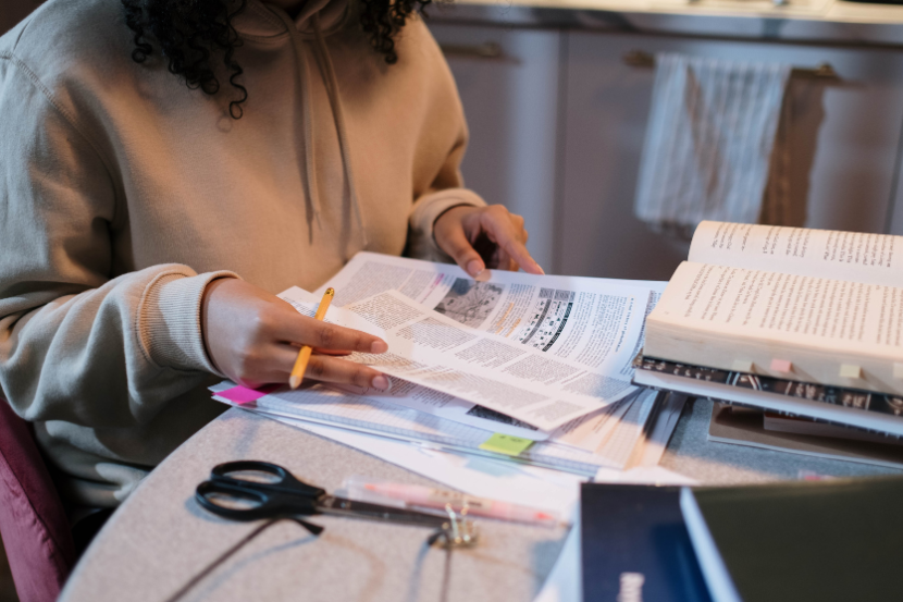 aluna estudando com livros e apostilas sobre a mesa