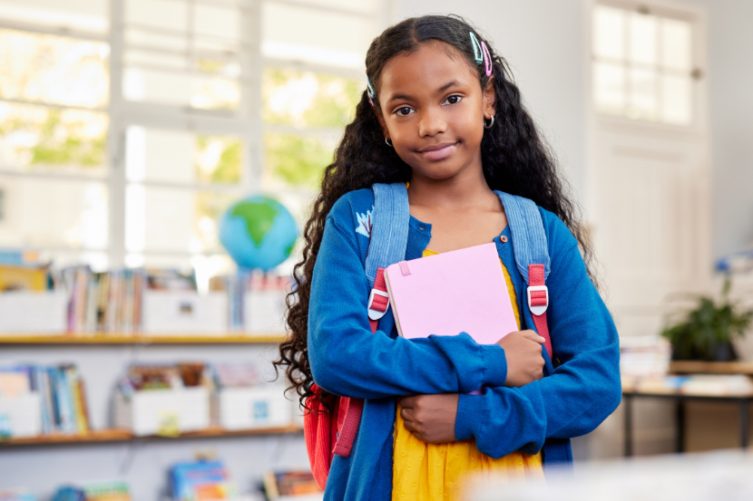 menina na escola segurando material