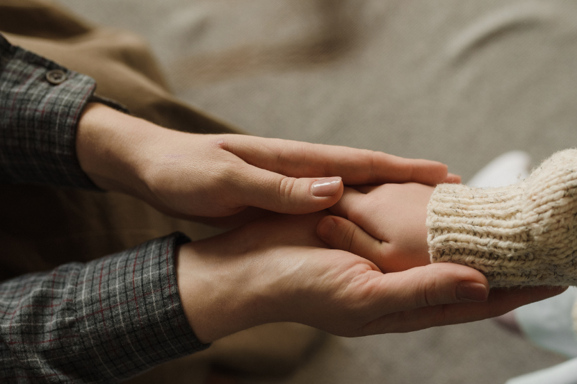 ECA Digital mão de adulto segurando mão de criança em sinal de proteção