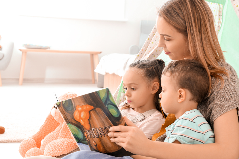 mãe lendo  com os dois filhos