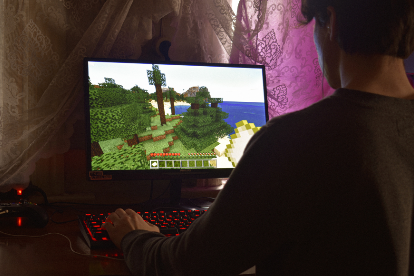 menino pré-adolescente jogando minecraft no computador