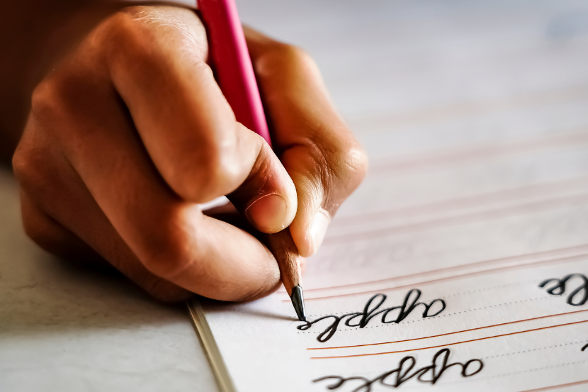 criança escrevendo com letra cursiva