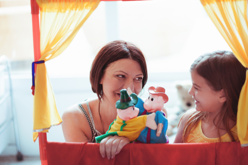 mãe e filha brincando de teatro com fantoches 
