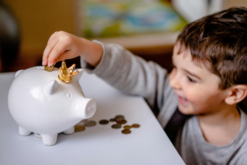 empreendedorismo infantil criança colocando moedas no porquinho