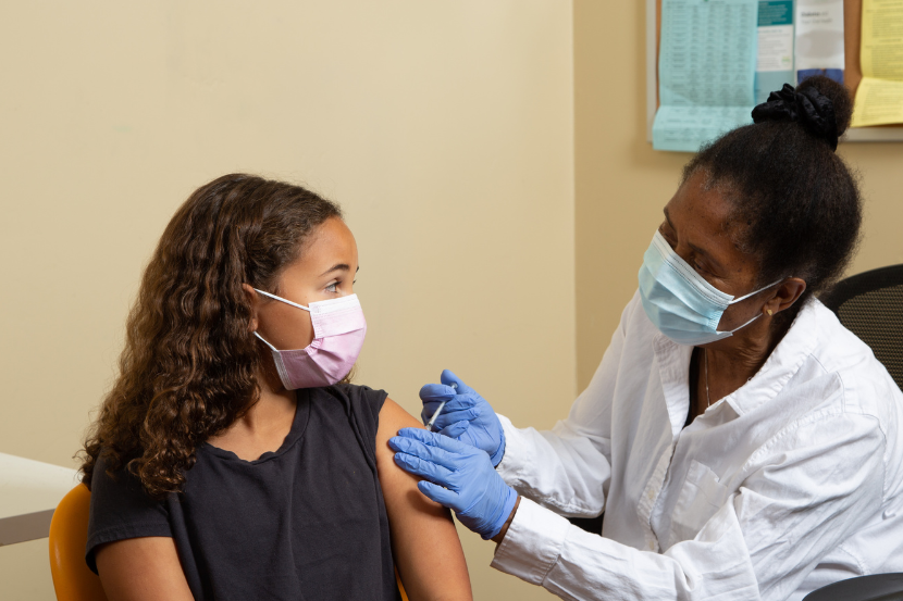 menina sendo vacinada por médica
