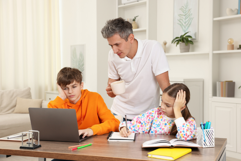 filhos mostrando boletim escolar para o pai no computador