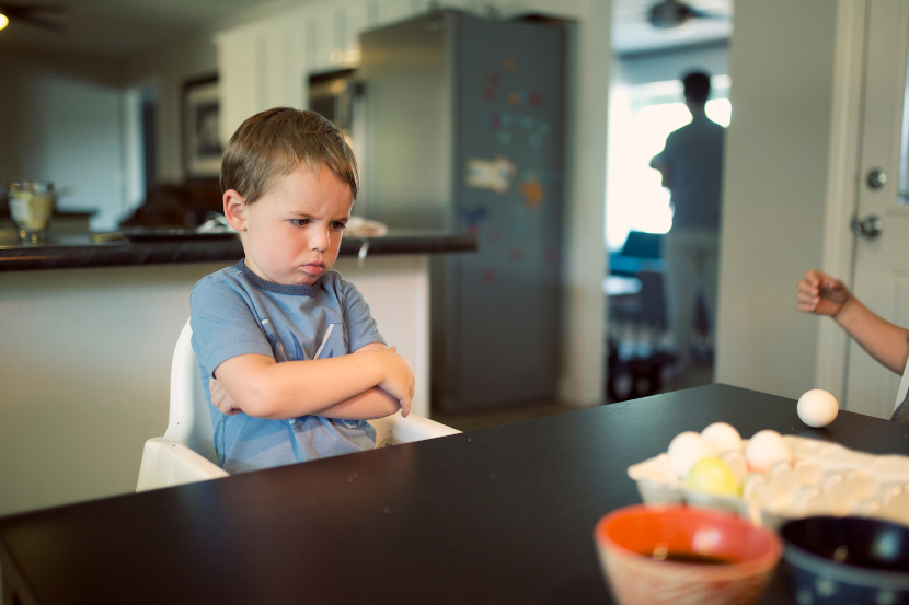 menino emburrado na mesa