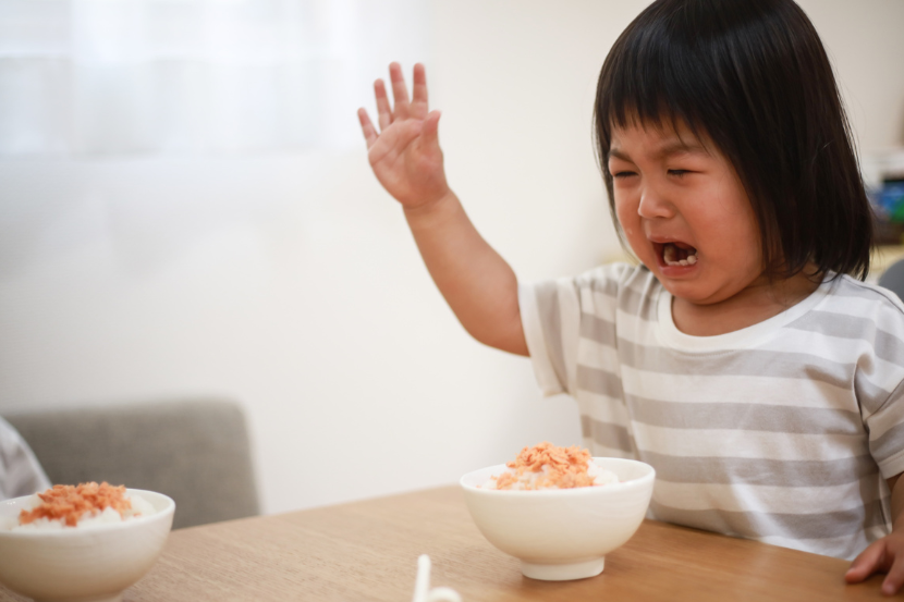 menina fazendo birra na mesa com tigela de comida