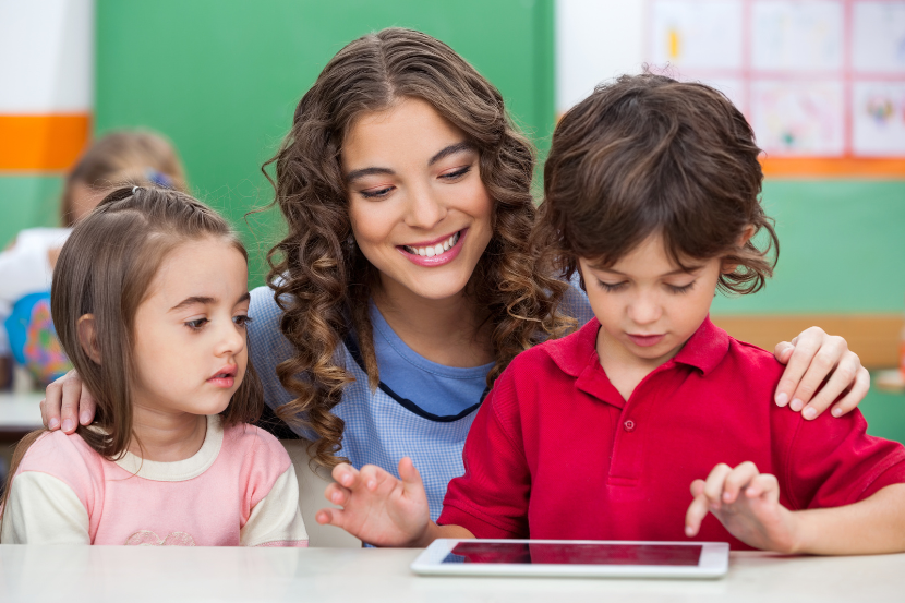 mãe ou professora ensinando as crianças a usar o tablet