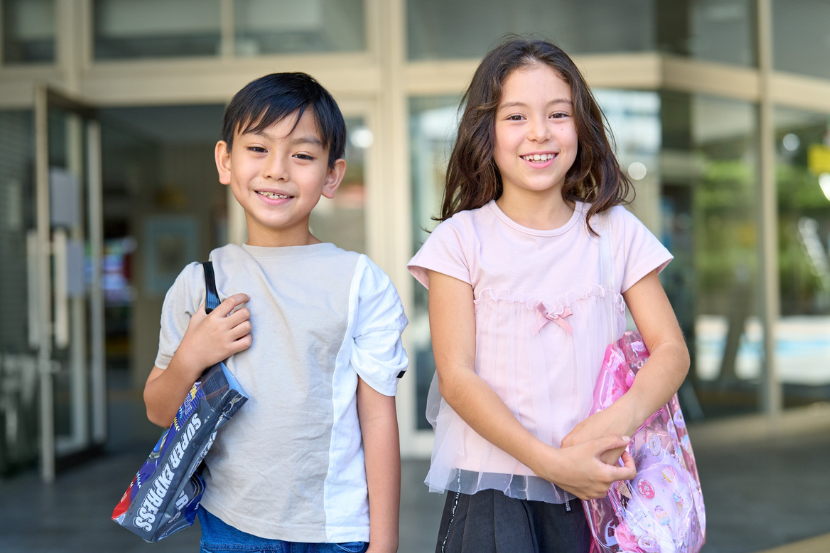 dois alunos com material escolar