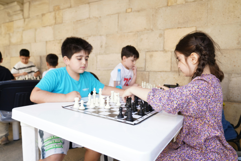 crianças jogando xadrez em campeonato