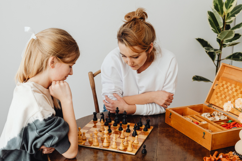 mãe ensinando xadrez para filha