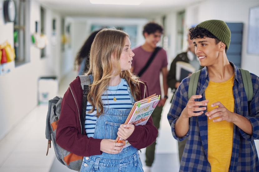 dois alunos do ensino médio conversando na escola