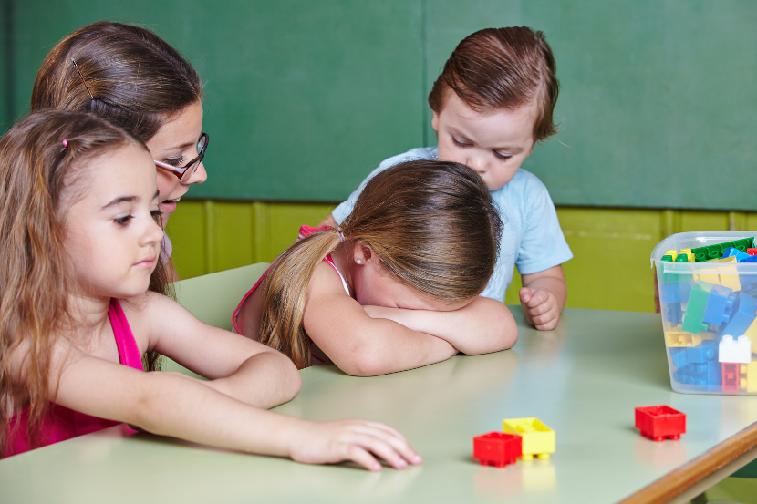 criança triste de cabeça baixa em sala de aula