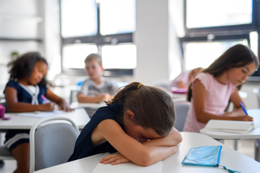 criança desanimada na sala de aula