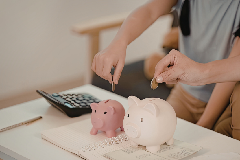 mensalidade escolar calculadora e moedas no porquinho representando planejamento de mensalidade escolar