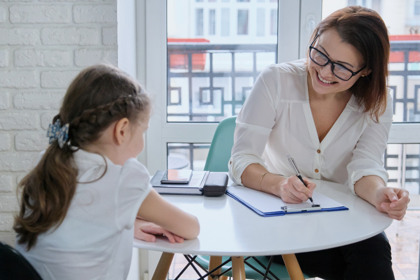 professora conversando com aluna em adaptação escolar