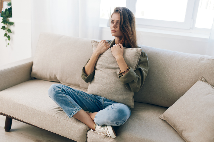 menina com ansiedade na adolescência aflita sentada no sofá