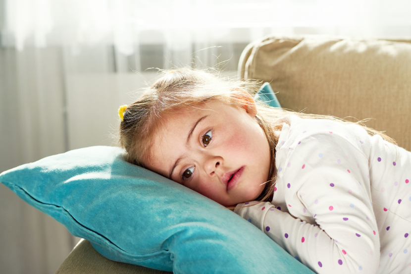 saúde mental infantil criança triste deitada no sofá com cabeça na almofada