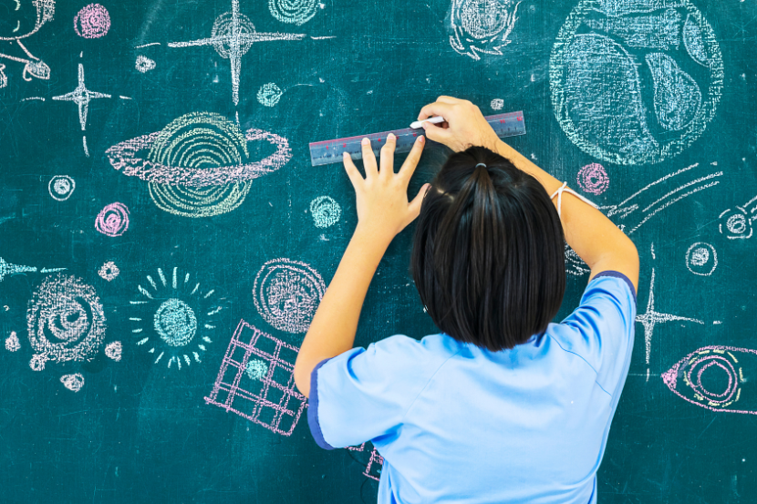 atividades sobre o Sistema Solar criança desenhando o sistema solar na lousa