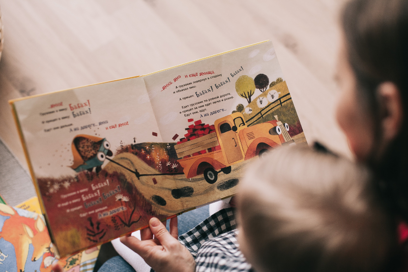 mãe lendo livro infantil para criança