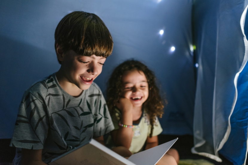 irmão lendo livro para irmã mais nova de 4 anos